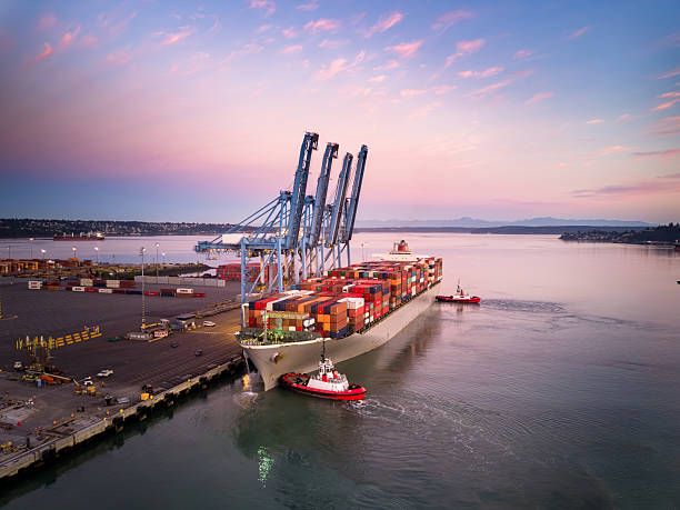 s6 A high angle still image of a cargo ship with numerous containers on Blair Waterway, parked on container terminal in the Port of Tacoma, Washington at sunrise.